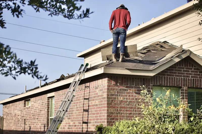 Professional roofer working on a residential roof in Lattingtown